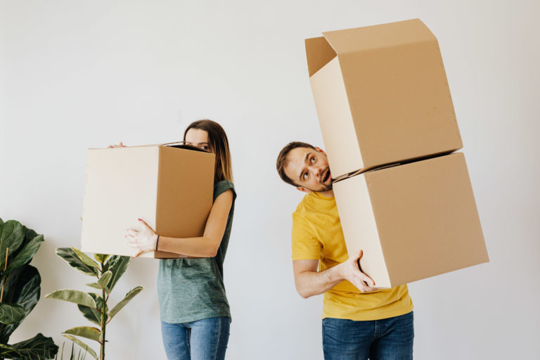 cheerful-couple-carrying-boxes-with-belongings-4506263
